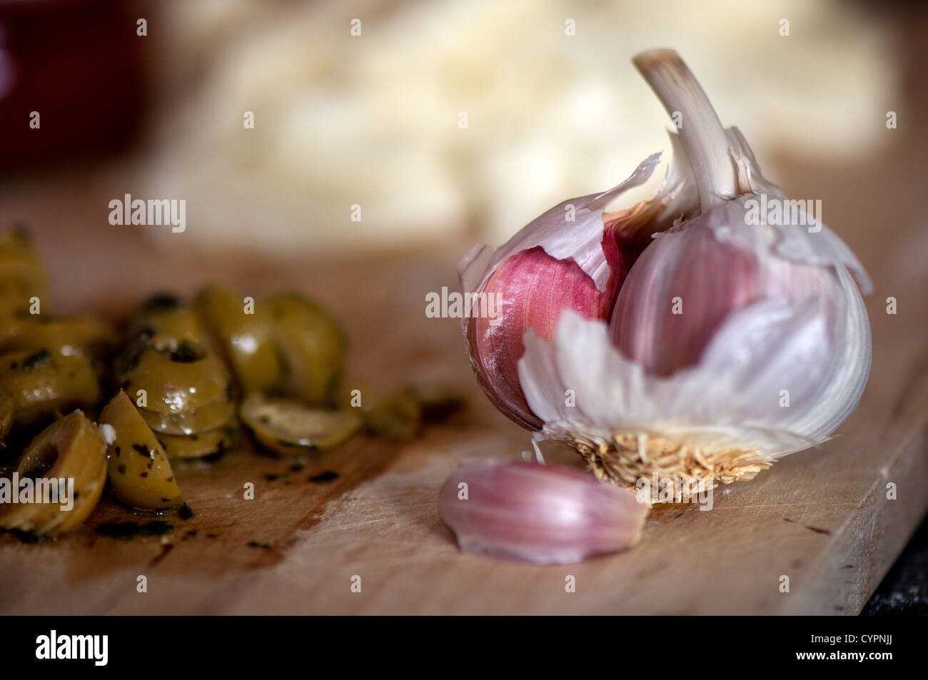Gousse d'ail et les olives sur une planche avec de la mozzarella fromage dans l'arrière-plan Banque D'Images
