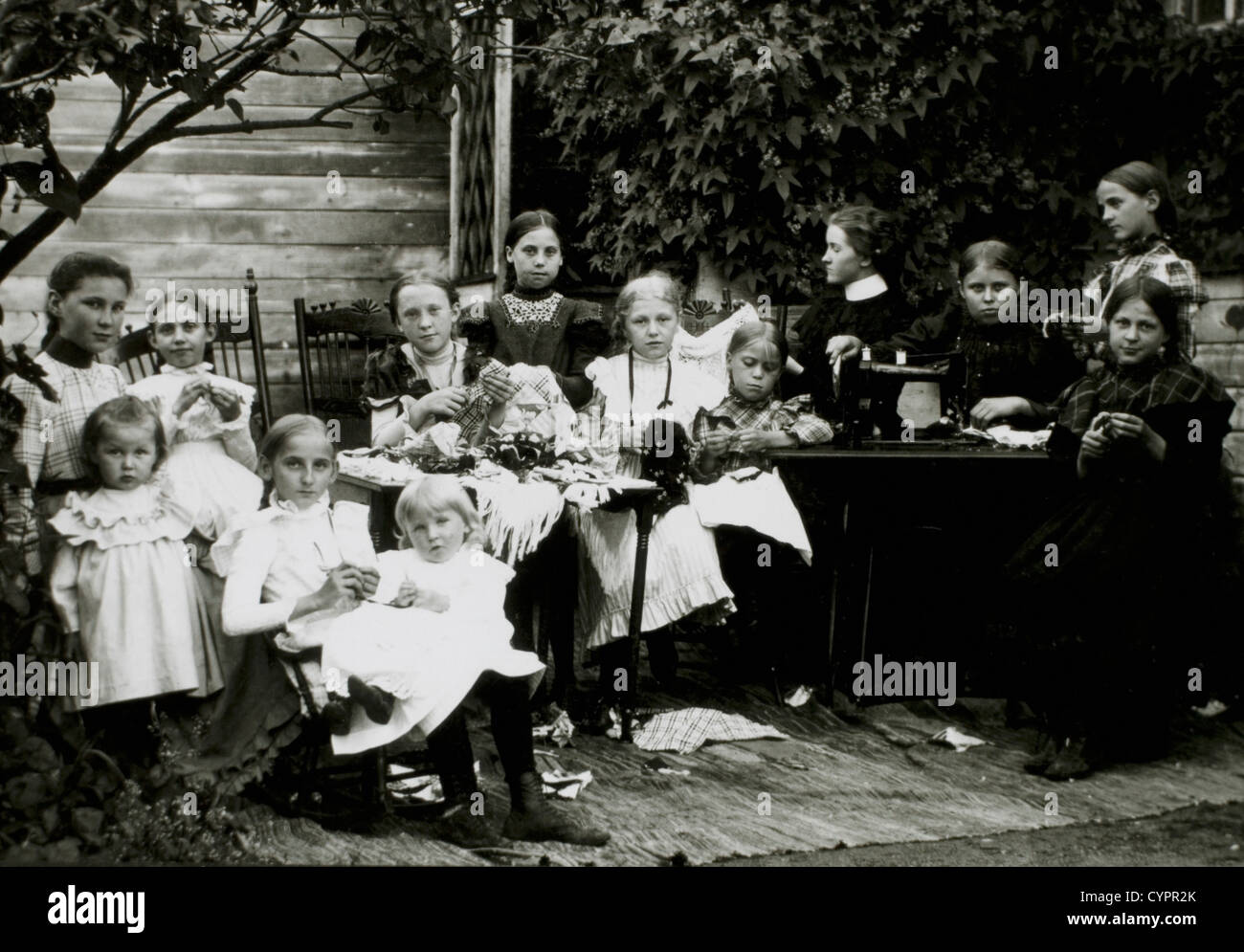 Groupe de femmes et d'enfants avec machine à coudre, Portrait, vers 1900 Banque D'Images