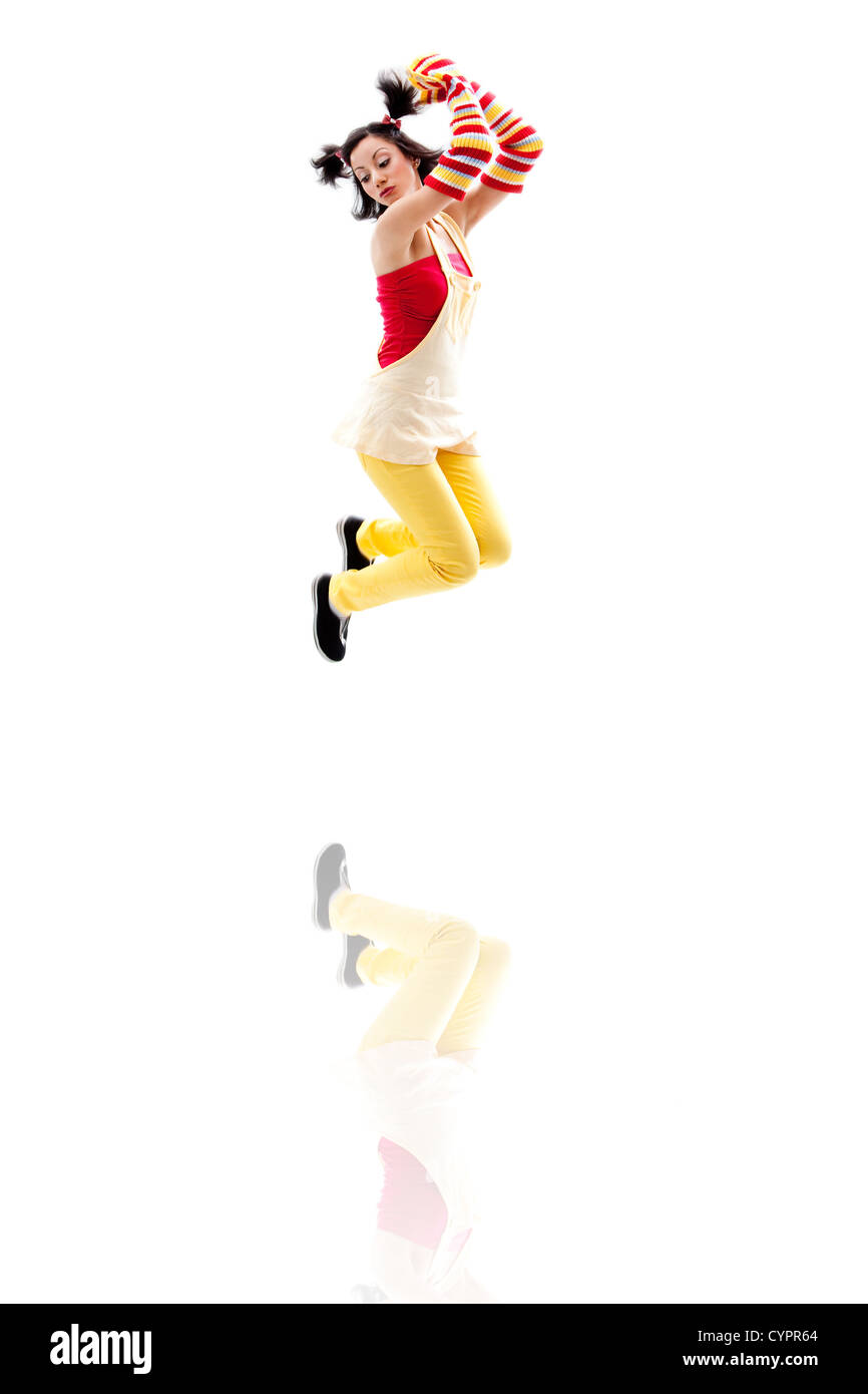Fille de Latina portant des vêtements jaune rouge sautant avec réflexion, isolé Banque D'Images