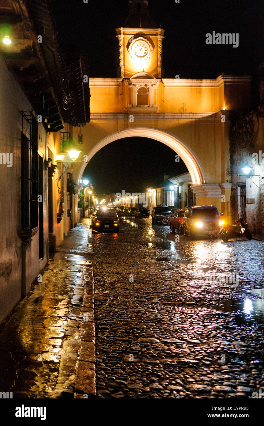 Arche de Santa Catalina Antigua Guatemala nuit // L'arche sur la rue du couvent de Santa Catalina dans le centre d'Antigua, Guatemala, avec l'eau de la pluie récente reflétant les lumières sur la rue pavée. Banque D'Images