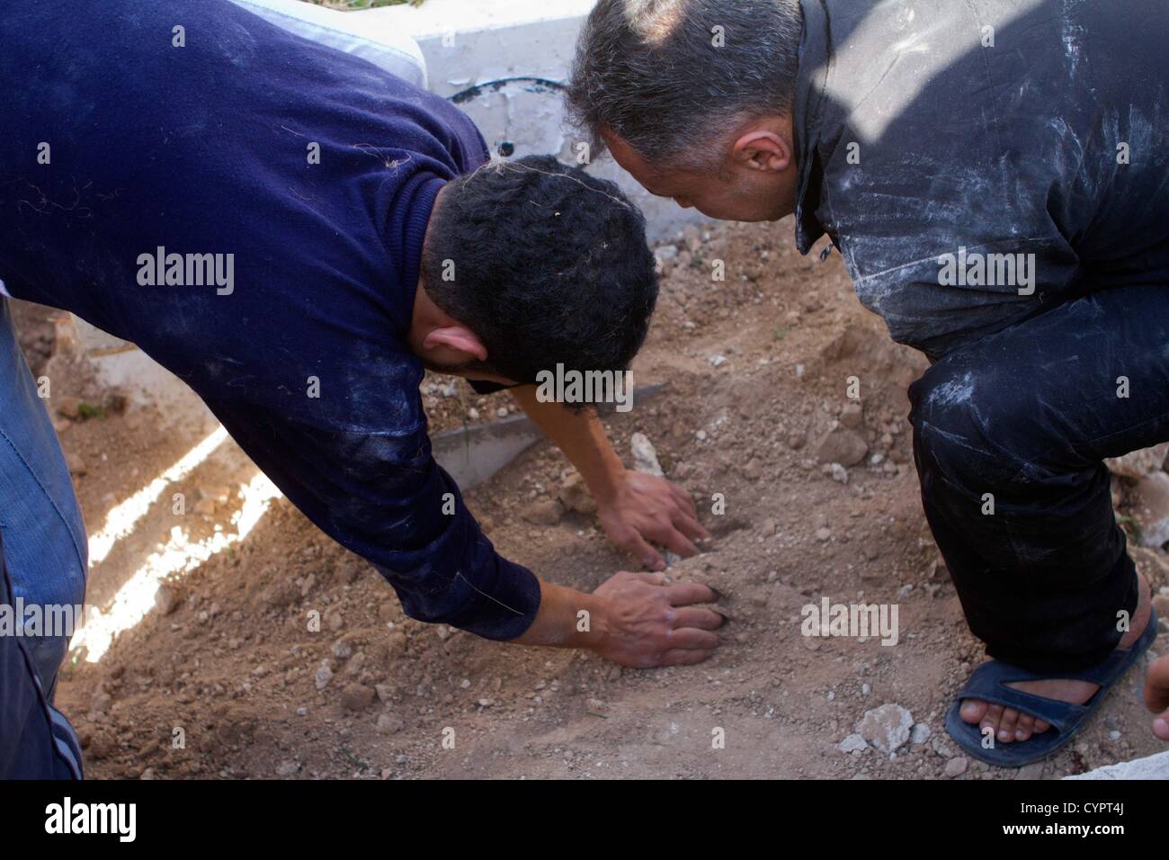 8 novembre 2012 - Alep, Syrie : Les hommes portent sur une tombe, lors d'un service funéraire pour un homme tué par un sniper dans Kadi quartier Askar d'Alep. Banque D'Images