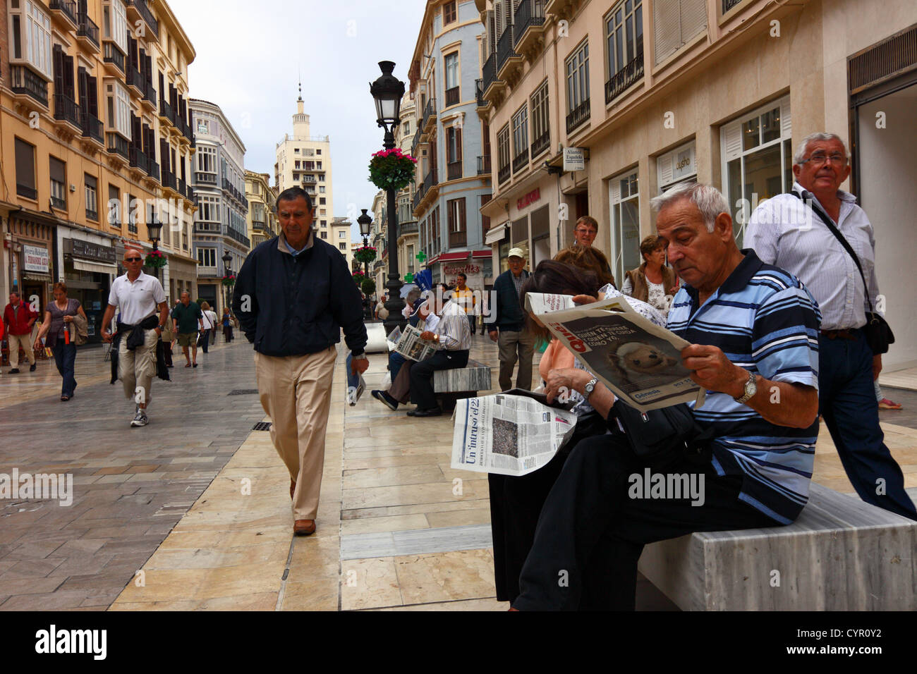 Les gens qui lisent les documents et promenade dans la Calle Larios, Malaga, Espagne Banque D'Images