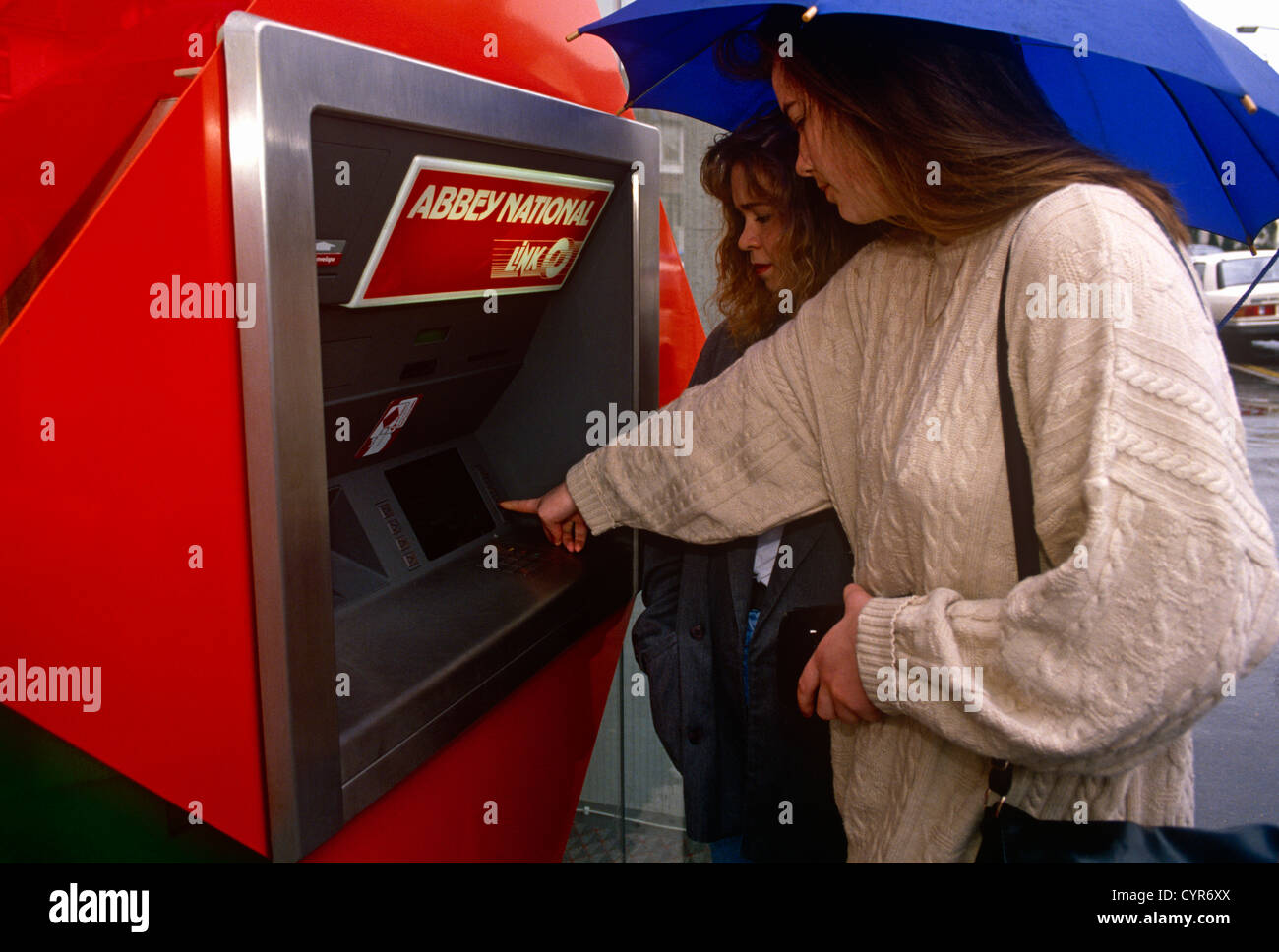 Jeune femme retire de l'argent de sa succursale de Londres local de l'Abbey National Building Society en 1989. Banque D'Images