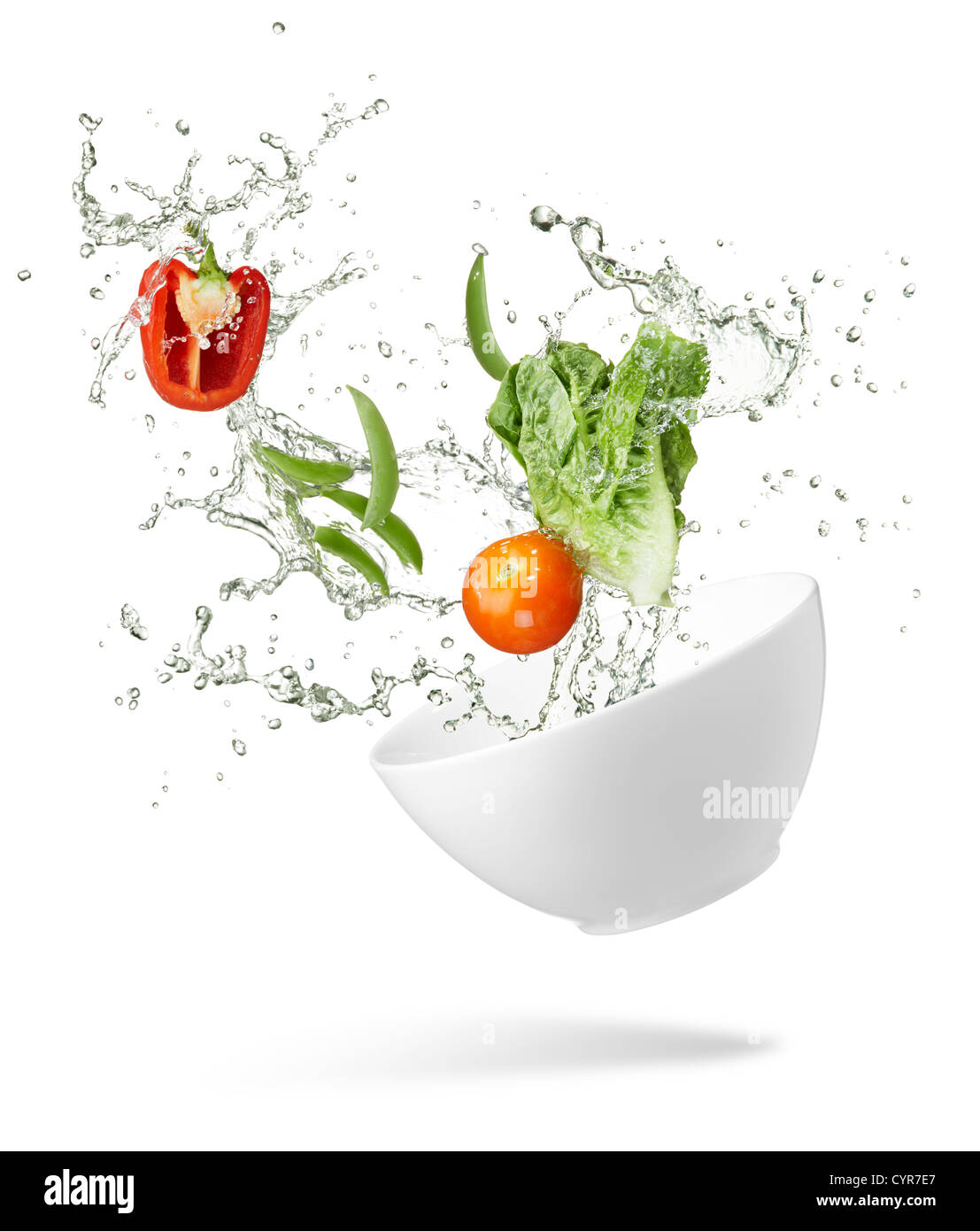 Divers types de légumes frais projection débordent de bol Banque D'Images
