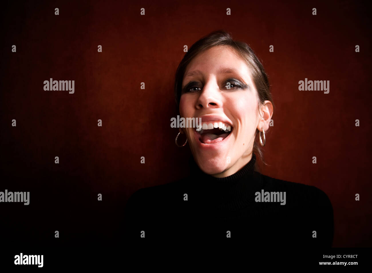 Jolie femme en riant dans un col roulé noir Banque D'Images