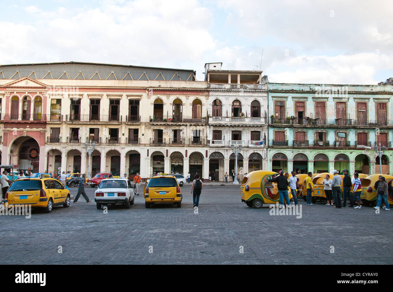 Cocotaxis et édifices en ruine à l'arrière-plan à La Havane, Cuba Banque D'Images