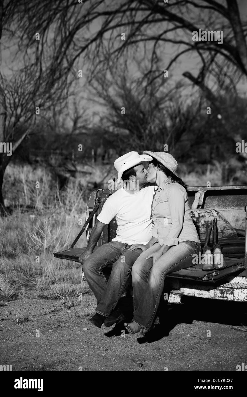 L'homme et la femme à chapeau de cowboy, baiser sur l'arrière du camion de ramassage Banque D'Images