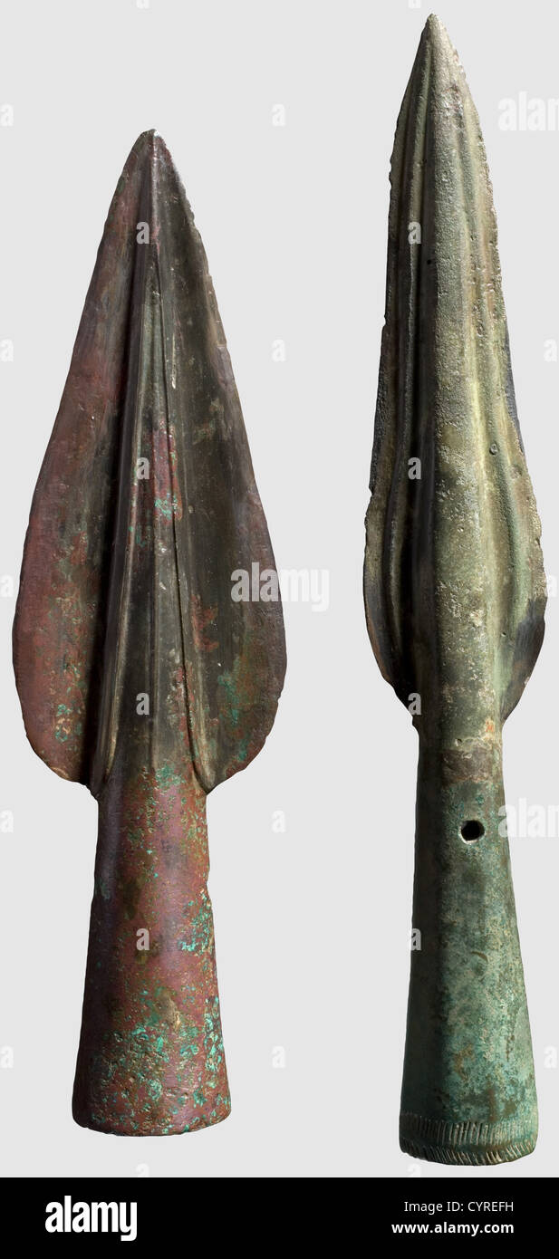 Deux fers de lance en bronze,Europe centrale,âge du bronze,vers 1000 B.C. Bronze avec marron,respectivement légère patine verdâtre. Une pointe de fer avec large, en forme de feuille, les bords partiellement restaurés. La nervure centrale arrondie est décorée de trois crêtes. Douille ronde légèrement conique avec deux trous de fixation. Le deuxième exemple présente un point mince avec des arêtes courbées, une nervure centrale arrondie avec deux arêtes sur les côtés. Douille légèrement conique avec deux trous de fixation et décor gravé à la base. Longueur 16.3 et 19.1 cm, historique, historique, monde antique, ancien, droits additionnels-Clearences-non disponible Banque D'Images