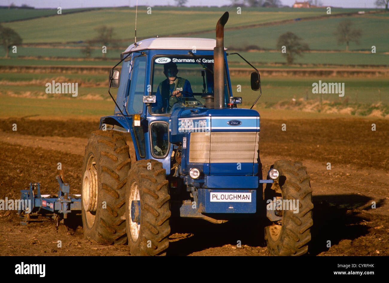 Un agriculteur laboure son champ à l'aide d'un tracteur Ford TW-25 dans le  Lincolnshire, en Angleterre Photo Stock - Alamy