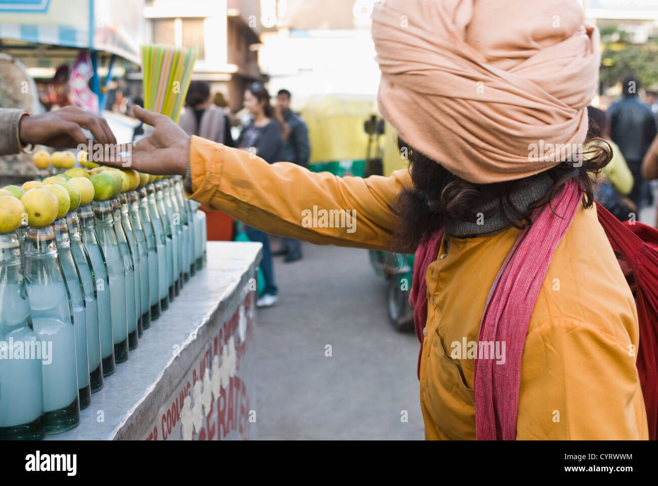 Vendeur de rue l'aumône à un mendiant, New Delhi, Inde Banque D'Images