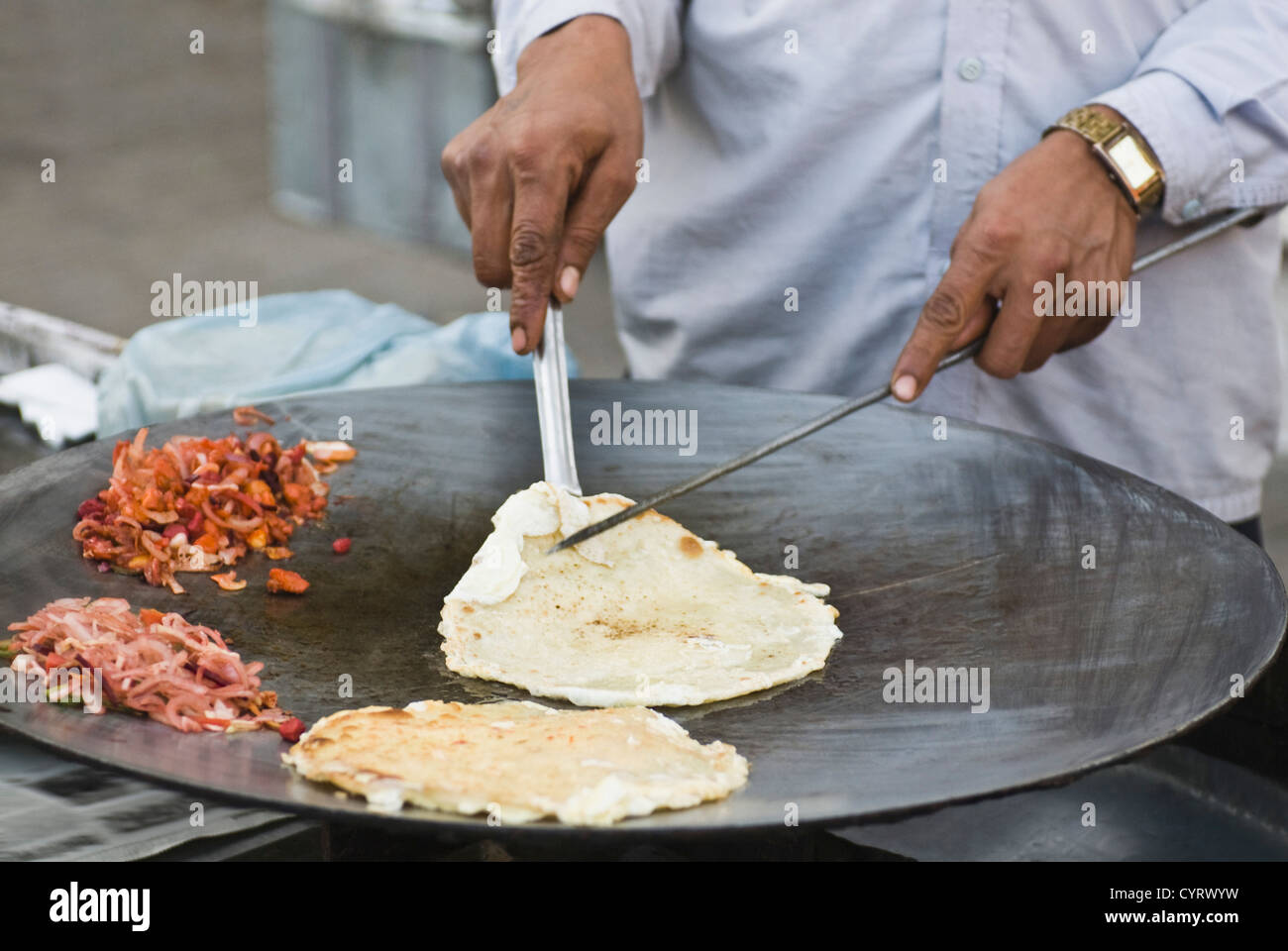 L'homme préparer egg roll dans une stalle, New Delhi, Inde Banque D'Images