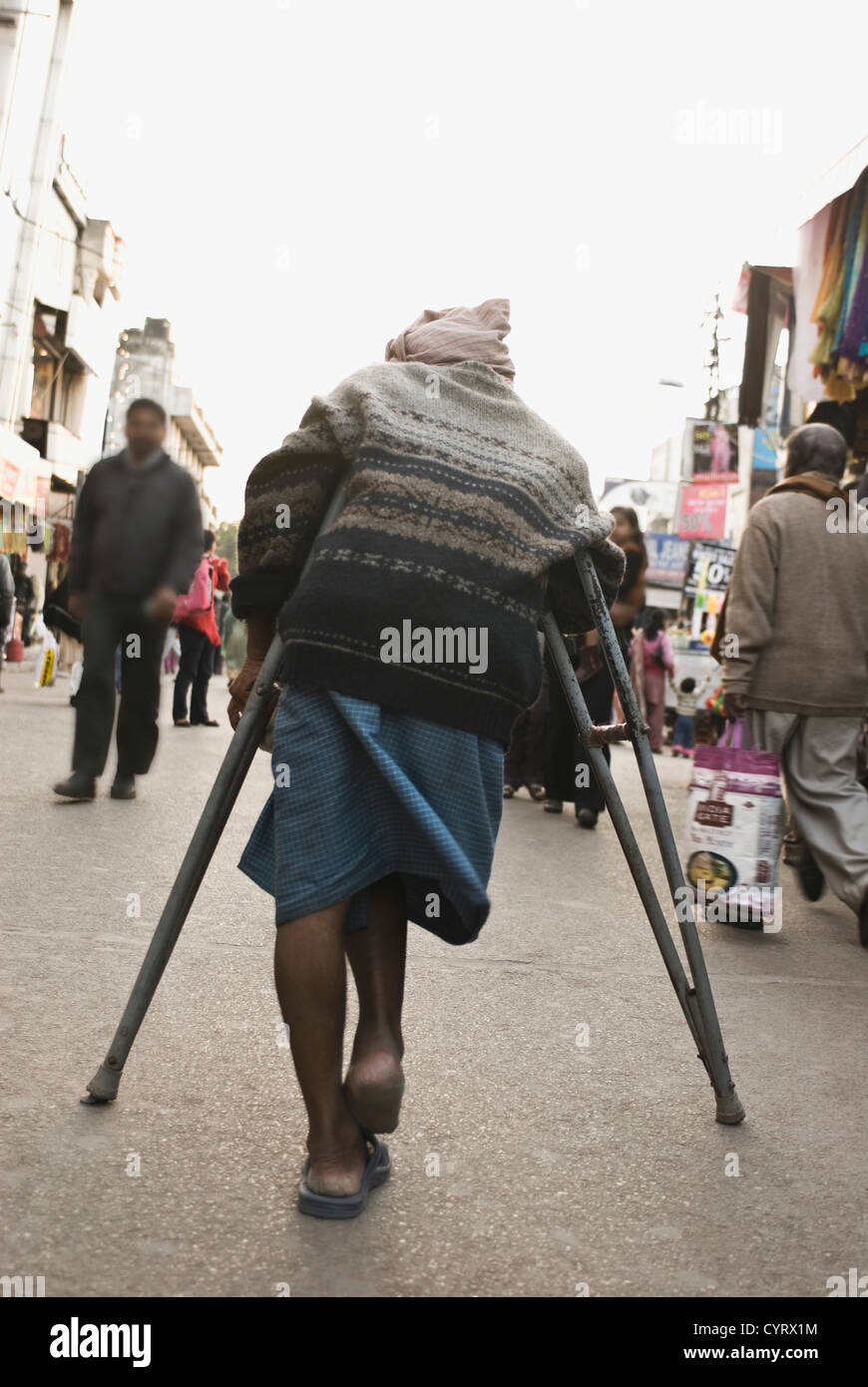 Vue arrière d'un homme handicapé dans un marché de rue, New Delhi, Inde Banque D'Images