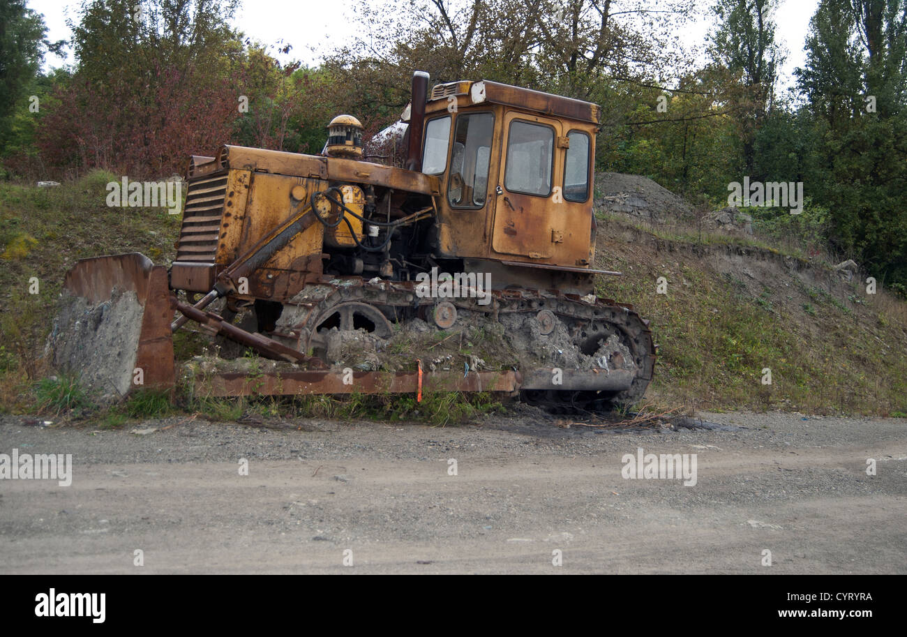 Vieux jaune sale bulldozer dans la forêt Banque D'Images