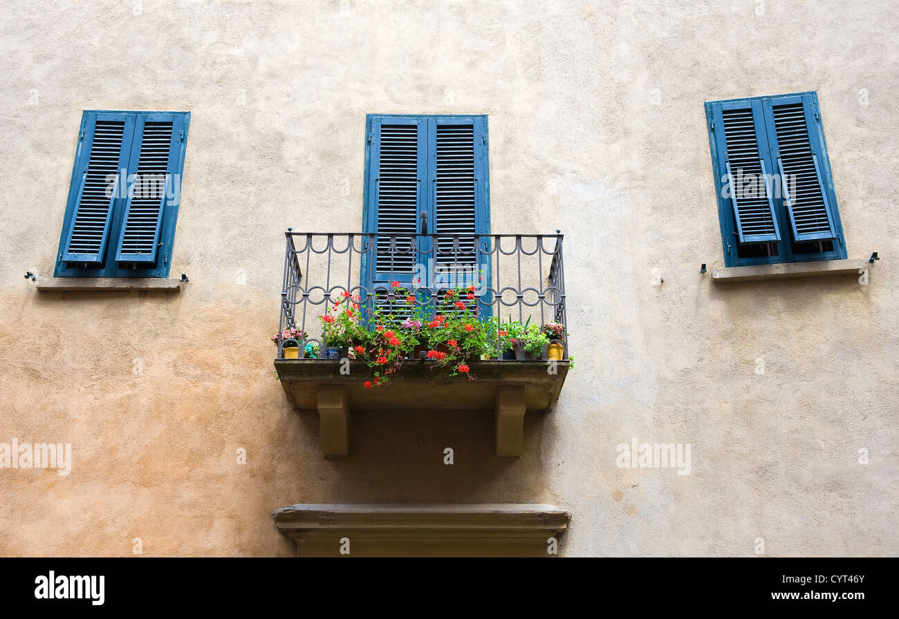 Un petit balcon sur une chambre, et volets peints en bleu à la mer méditerranée. Banque D'Images