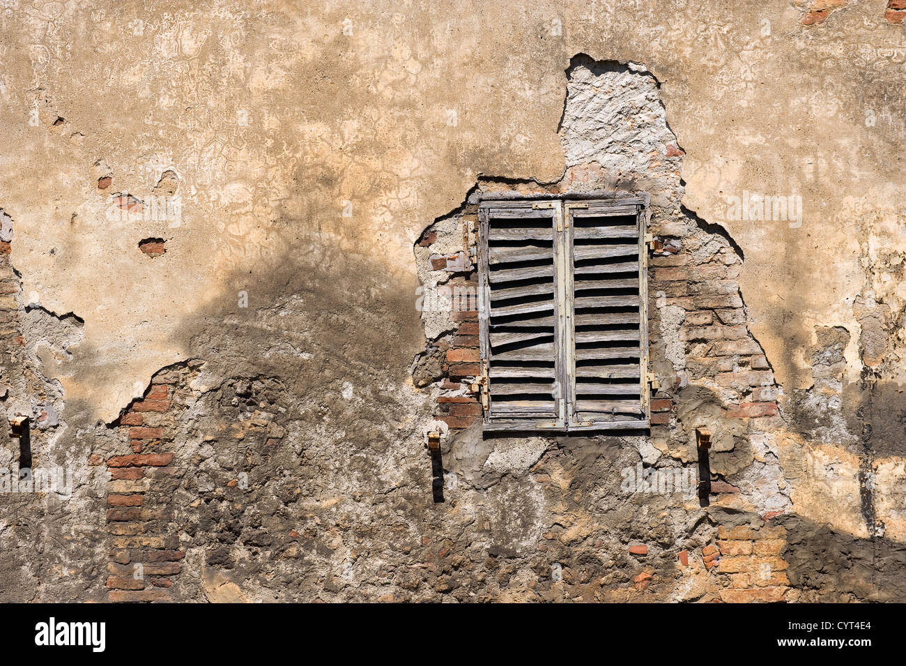 Une partie d'un vieux mur avec fenêtre d'une maison en Toscane en Italie. Banque D'Images