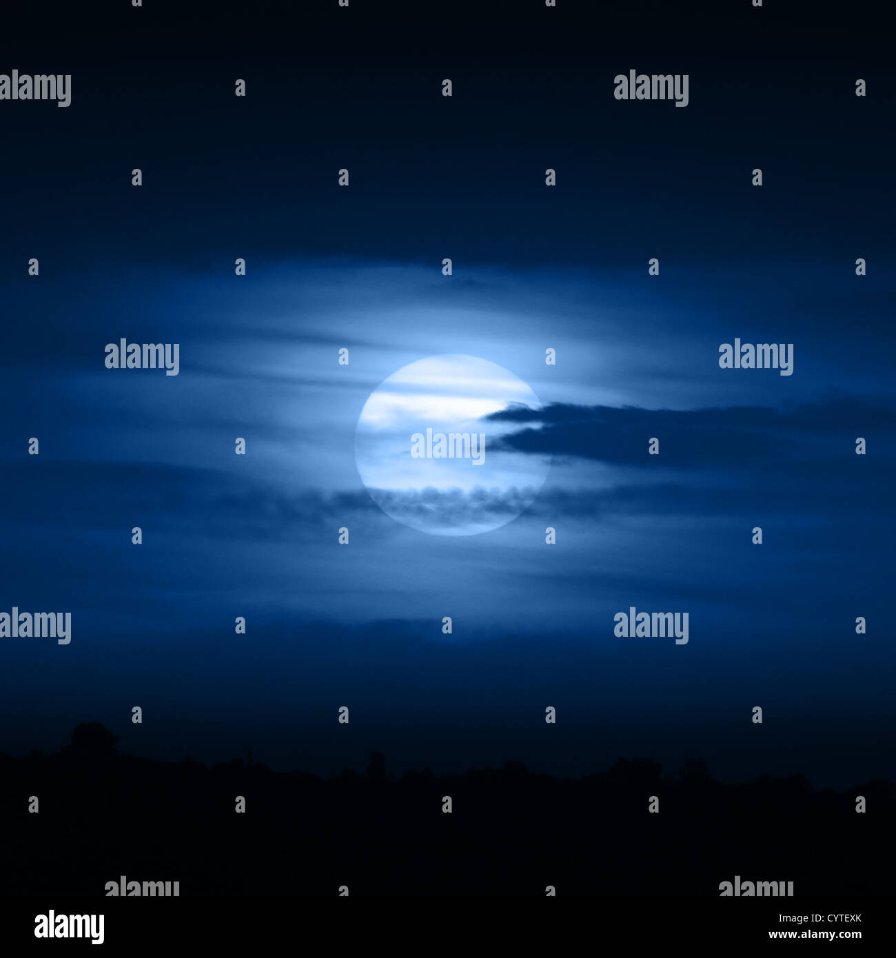 Pleine lune en bleu nuages de nuit Banque D'Images