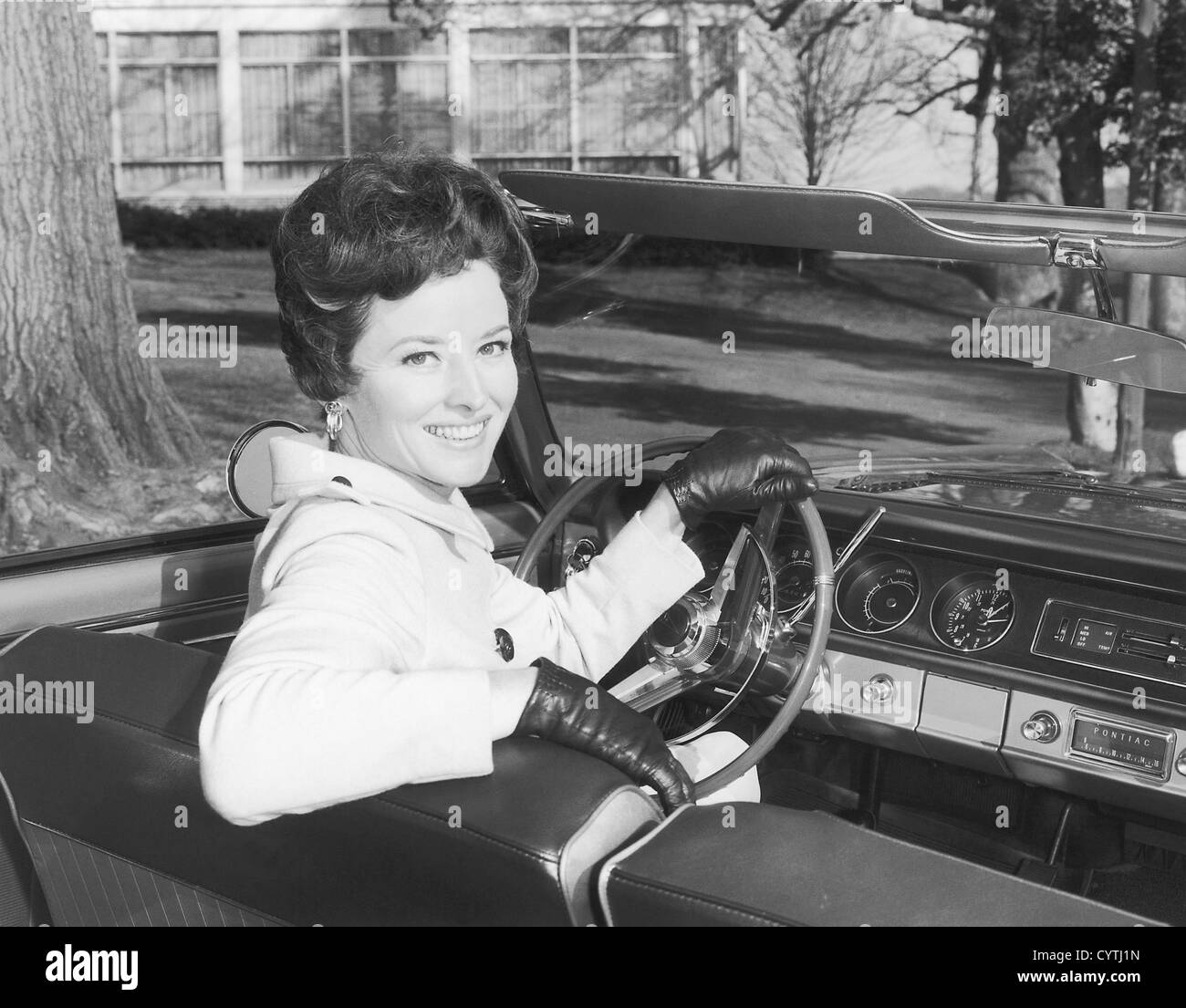 Portrait de femme assise derrière la roue de voiture Banque D'Images