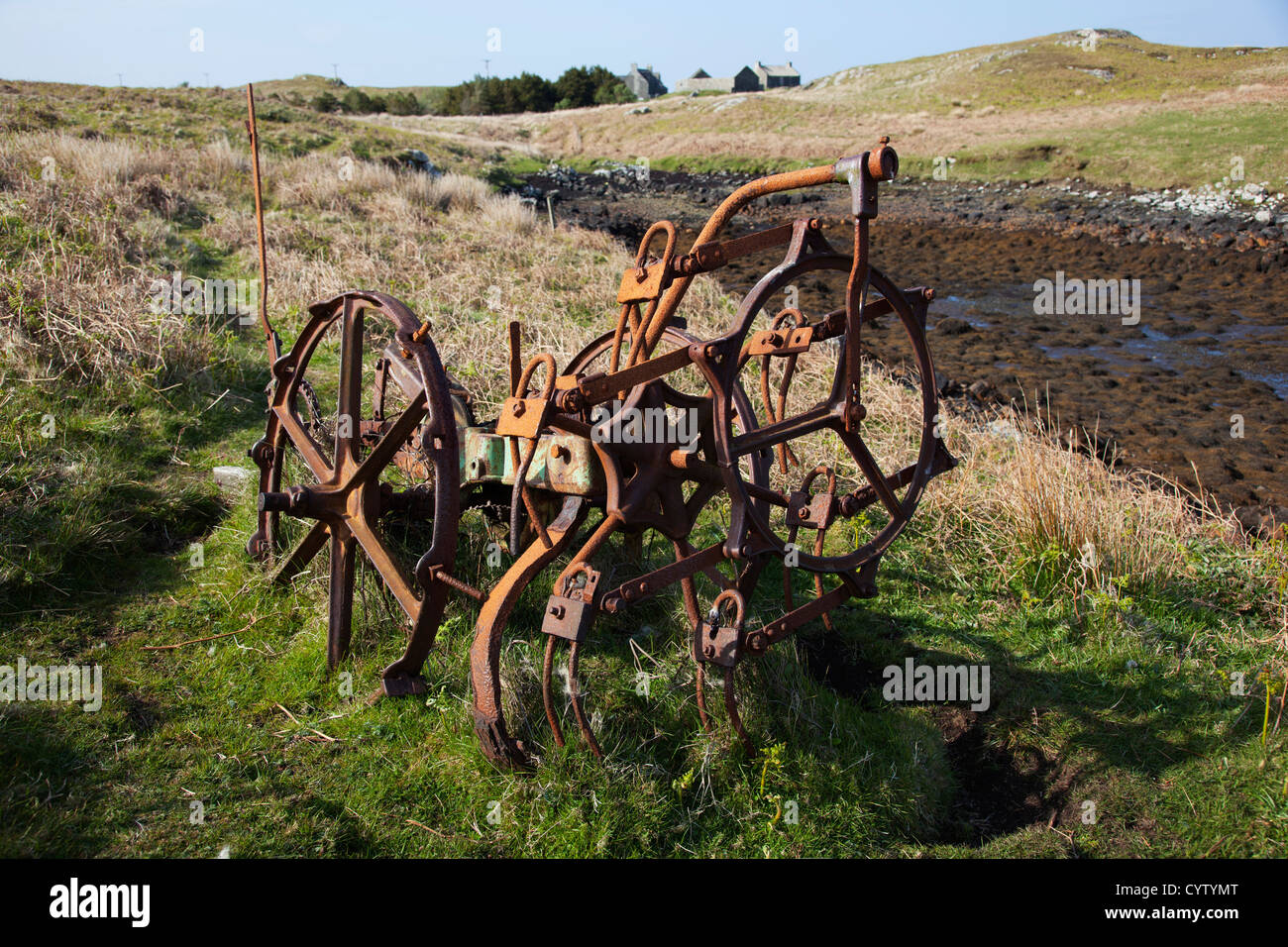 Rusty old farm machinery abandonnés dans un champ près de Flodaigh Benbecular sur, Hébrides extérieures, en Écosse, Royaume-Uni Banque D'Images