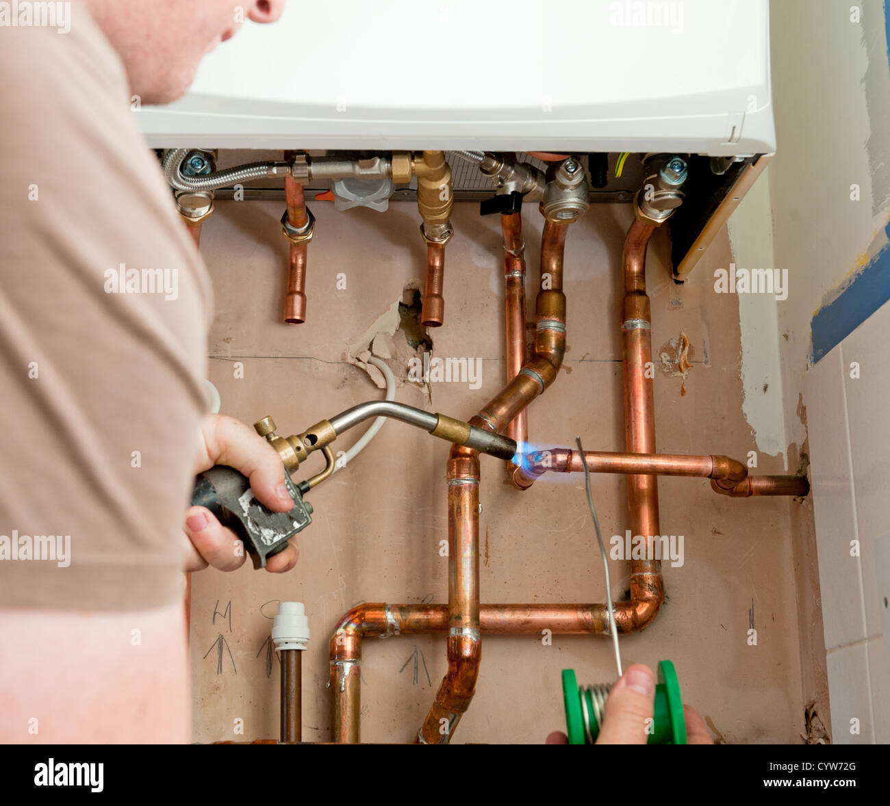Portrait d'une situation réelle où un ingénieur chauffage tuyaux en cuivre  à souder est une nouvelle chaudière pour le chauffage central Photo Stock -  Alamy