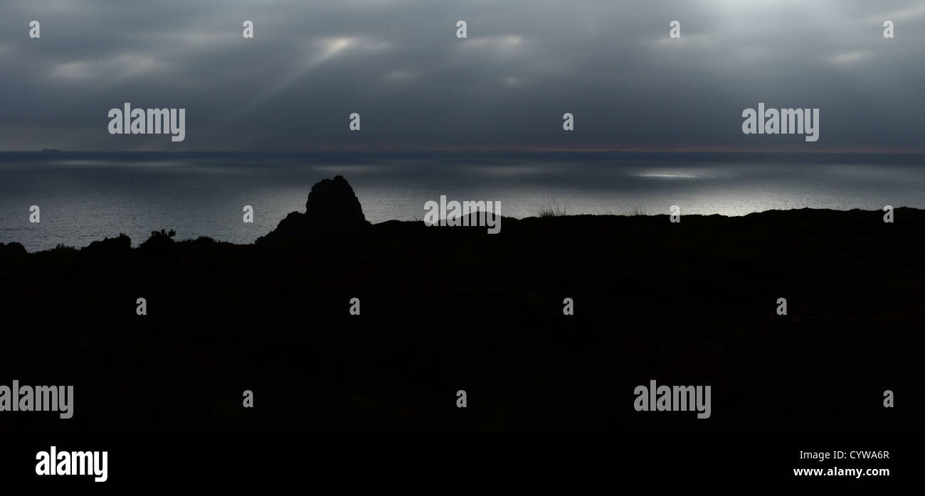 Rayons crépusculaires qui se reflète sur la surface d'une mer calme, Kynance Cove, un lézard péninsulaire, Cornwall, England, UK. Banque D'Images