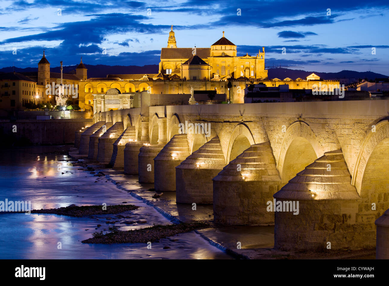 Pont romain sur le Guadalquivir et la mosquée cathédrale (la mezquita) allumé à la tombée de la nuit dans la ville de Cordoba, Espagne. Banque D'Images