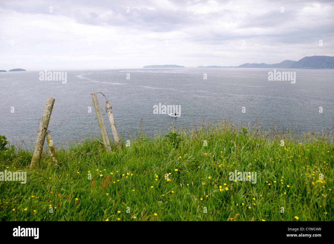 BEAUMARIS, pays de Galles — les eaux du détroit de Menai s'étendent de Beaumaris sur l'île d'Anglesey. Cet étroit canal d'eau de marée sépare Anglesey du pays de Galles continental, avec les montagnes de Snowdonia visibles à l'horizon. Le détroit relie la mer d'Irlande à la baie de Caernarfon et est connu pour ses forts courants de marée. Beaumaris, situé sur la côte sud-est d'Anglesey, se trouve le long de cette voie navigable qui a servi de route maritime importante pendant des siècles. La ville est située à proximité du continent gallois de l'autre côté du détroit. Banque D'Images