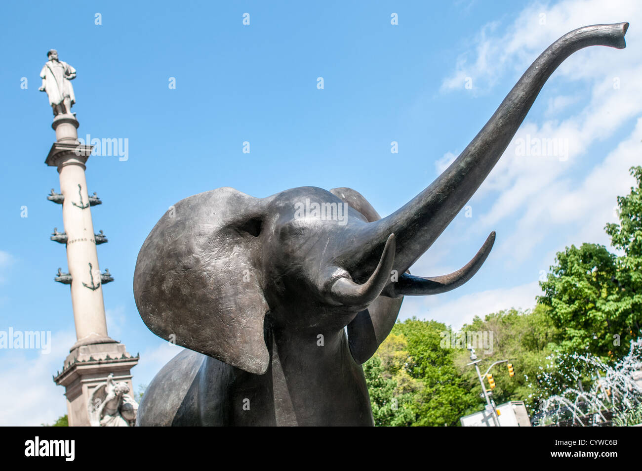 NEW YORK, NY, États-Unis — Une sculpture grandeur nature d'éléphant en bronze réalisée par l'artiste Peter Woytuk se tient bien en vue sur Broadway dans le cadre d'une exposition d'art publique mettant en vedette la faune. En arrière-plan, l’imposant monument de Colomb s’élève, créant une juxtaposition saisissante entre le paysage urbain et l’installation d’art naturaliste. Cette exposition unique transforme la rue animée en galerie à ciel ouvert, apportant art et nature au cœur de Manhattan. Banque D'Images