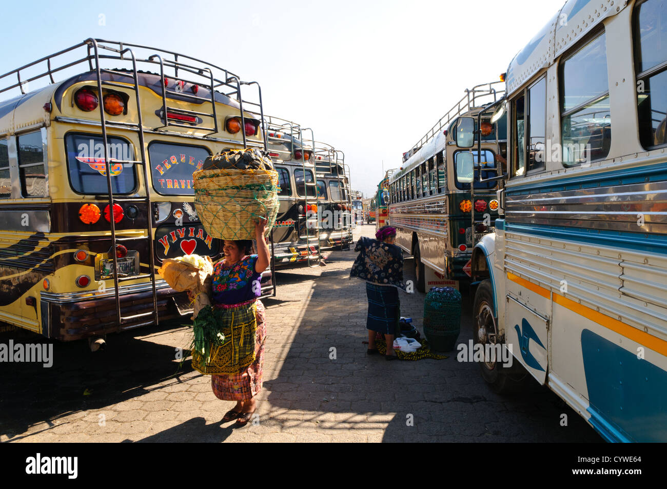 Bus de poulet Antigua Guatemala // ANTIGUA GUATEMALA, Guatemala — des bus de poulet peints colorés bordent une rue à Antigua Guatemala. Ces autobus scolaires américains réorientés, ornés de motifs vibrants et d'accessoires chromés, sont prêts à transporter les habitants et les touristes aventureux, incarnant la culture animée des transports du Guatemala dans le contexte de l'architecture coloniale. Banque D'Images