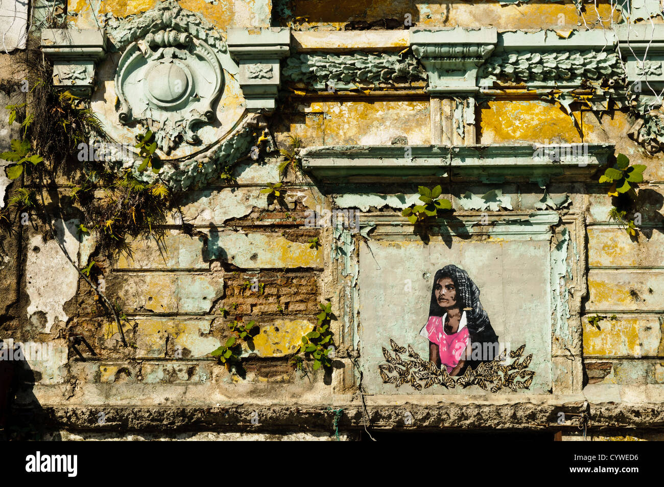 La ville de Guatemala, Guatemala - détails architecturaux d'un bâtiment colonial délabré avec la peinture d'une femme dans le centre-ville de Guatemala City, Guatemala. Banque D'Images