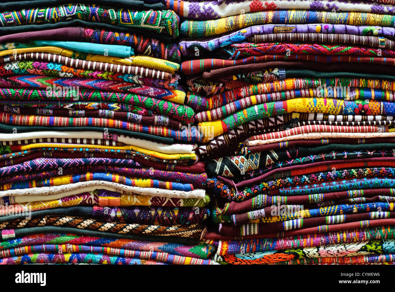 Textiles tissés aux couleurs vives sont empilés dans un marché à Antigua Guatemala. Le Guatemala a une très forte tradition de tissage sur métier à l'aide de divers types de métiers à tisser. Célèbre pour son bien-préservé l'architecture baroque espagnole ainsi qu'un certain nombre de ruines de tremblements, Antigua Guatemala est un UNESCO World Heritage Site et ancienne capitale du Guatemala. Banque D'Images
