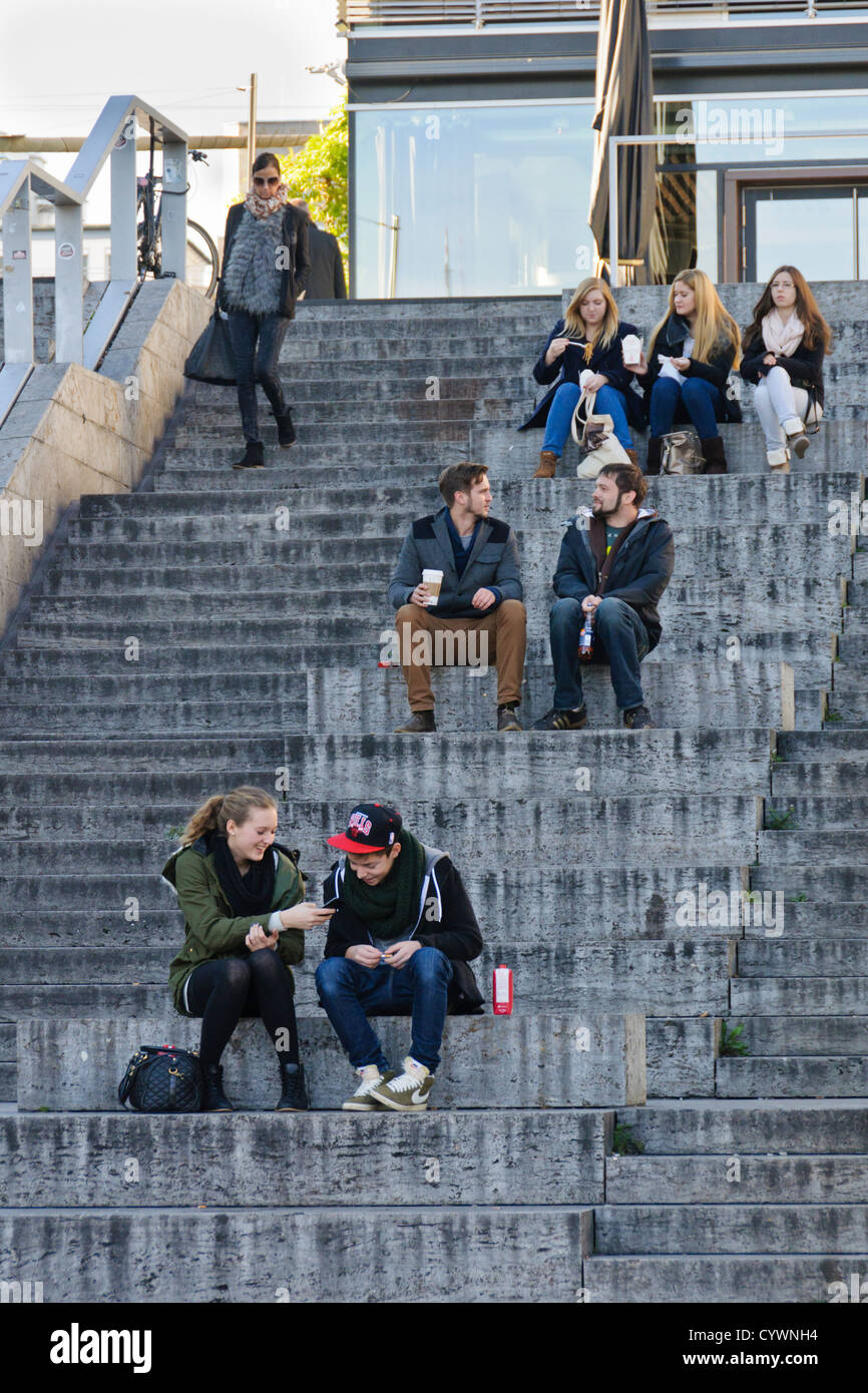 Les jeunes gens assis sur un escalier chat - Stuttgart, Königstrasse, Bade-Wurtemberg, Allemagne du Sud Banque D'Images