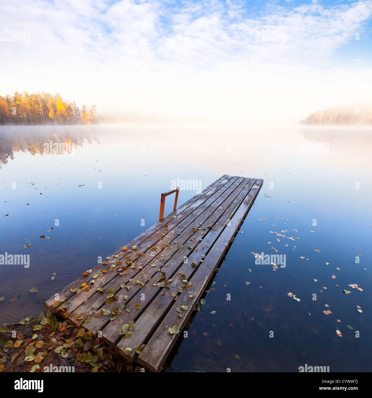 Petite jetée en bois sur le lac toujours en automne lumineux matin brumeux Banque D'Images