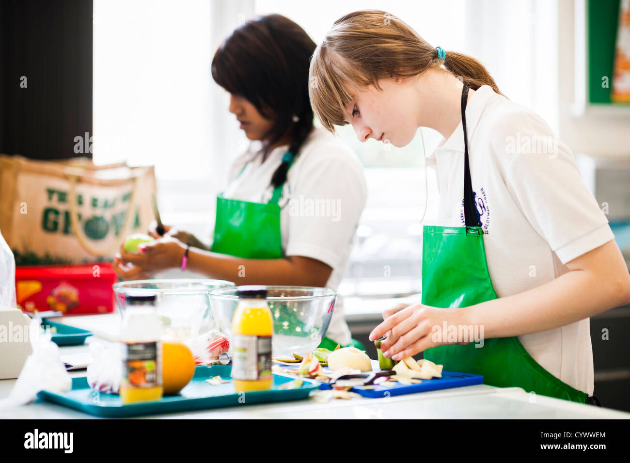 Deux jeunes filles la préparation de légumes dans un cours de technologie alimentaire dans une école secondaire, le Pays de Galles UK Banque D'Images