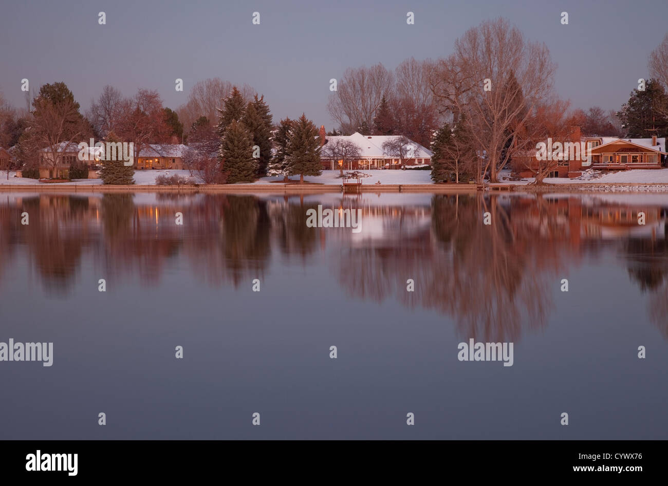 Logements de Luxe avec des arbres sur les rives d'un lac au crépuscule dans un paysage d'hiver, Fort Collins, Colorado Banque D'Images