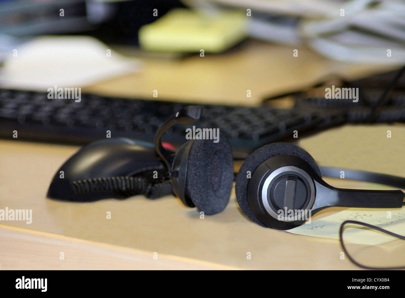 Casque sur bureau informatique avec clavier en arrière-plan. Banque D'Images