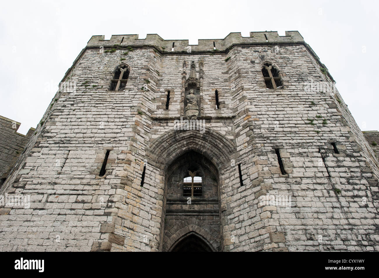CAERNARFON, Pays de Galles - le château de Caernarfon à gatehouse principal dans le nord-ouest du pays de Galles. Un château s'élevait à l'origine sur le site remontant à la fin du xie siècle, mais à la fin du 13e siècle, le Roi Edward J'ai commandé une nouvelle structure qui se tient à ce jour. Il possède des tours et est l'un des mieux conservés de la série de châteaux-QUE J'ai commandé. Banque D'Images