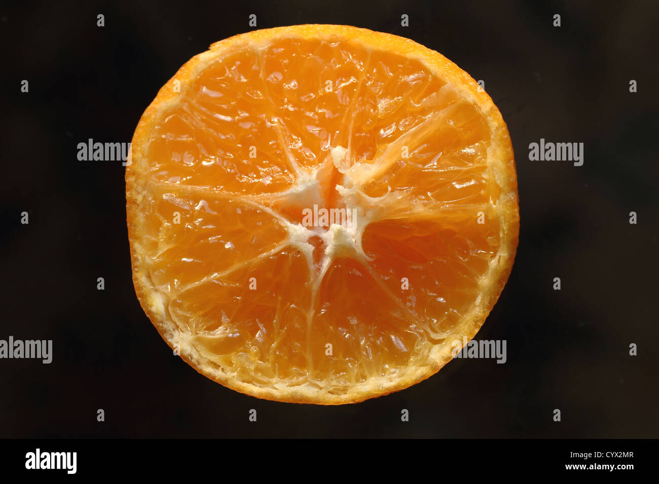Une orange juteuse la moitié sur un fond noir Banque D'Images