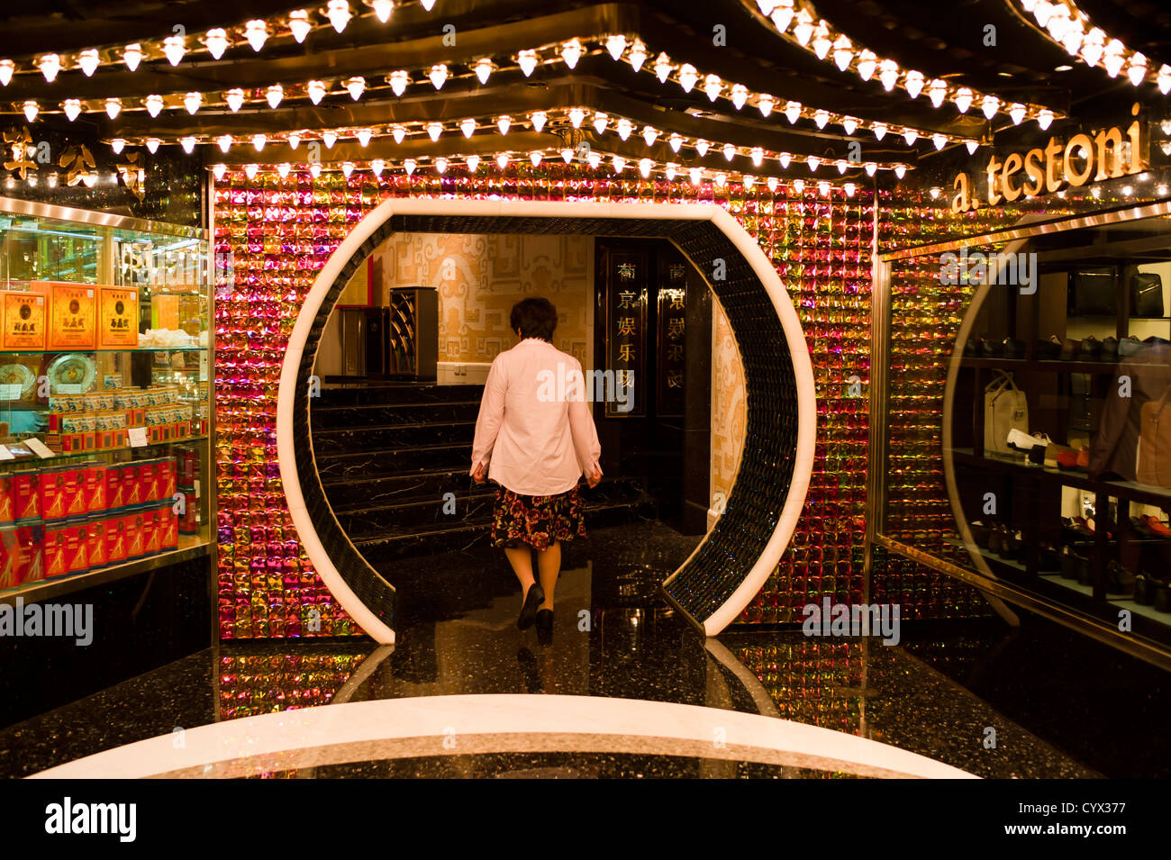 Femme chinoise entre dans la zone de jeu dans un casino de Macao par le feng shui porte. Banque D'Images