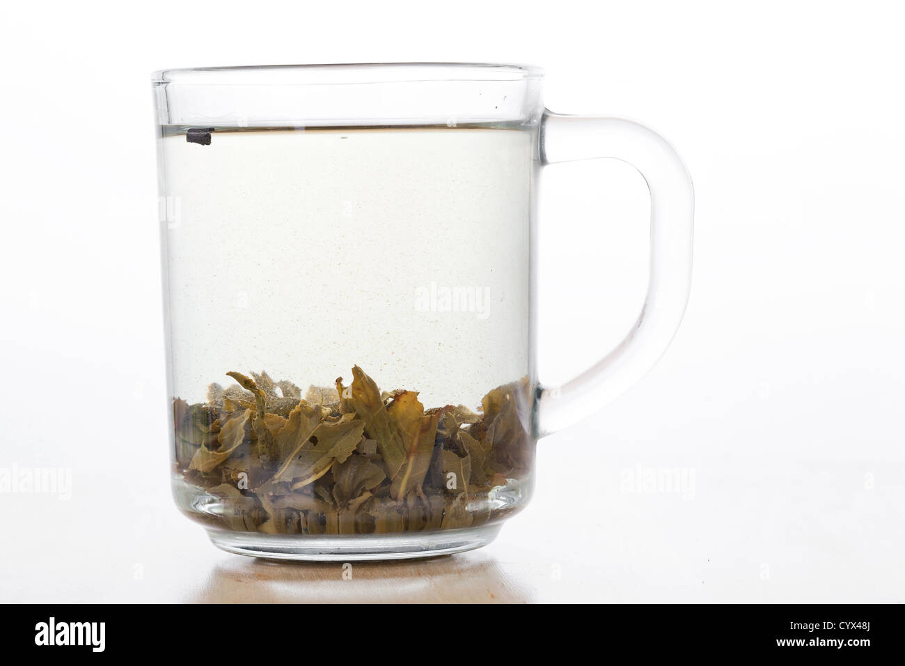 Tasse en verre de thé vert avec des feuilles, closeup Banque D'Images