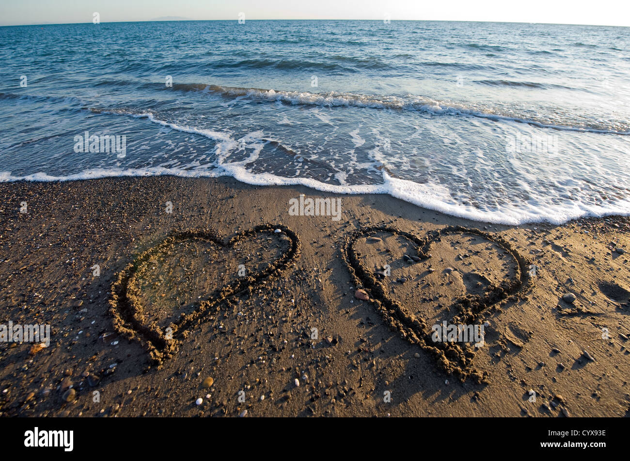 Deux cœurs dessinés dans le sable d'une plage Banque D'Images