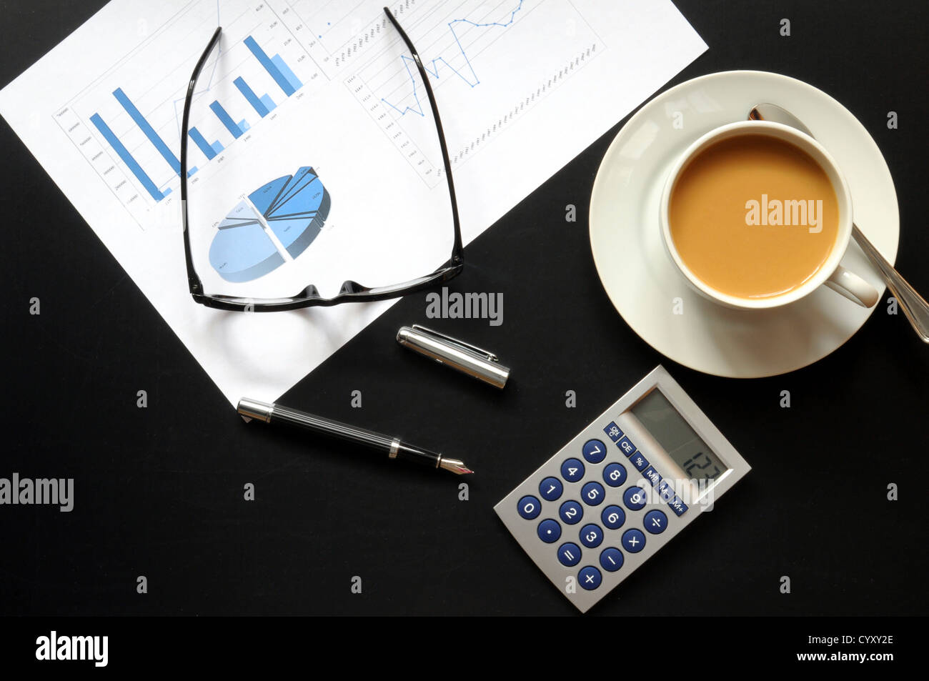 Petit-déjeuner d'affaires au bureau Le bureau noir avec stylo calculatrice et verres Banque D'Images