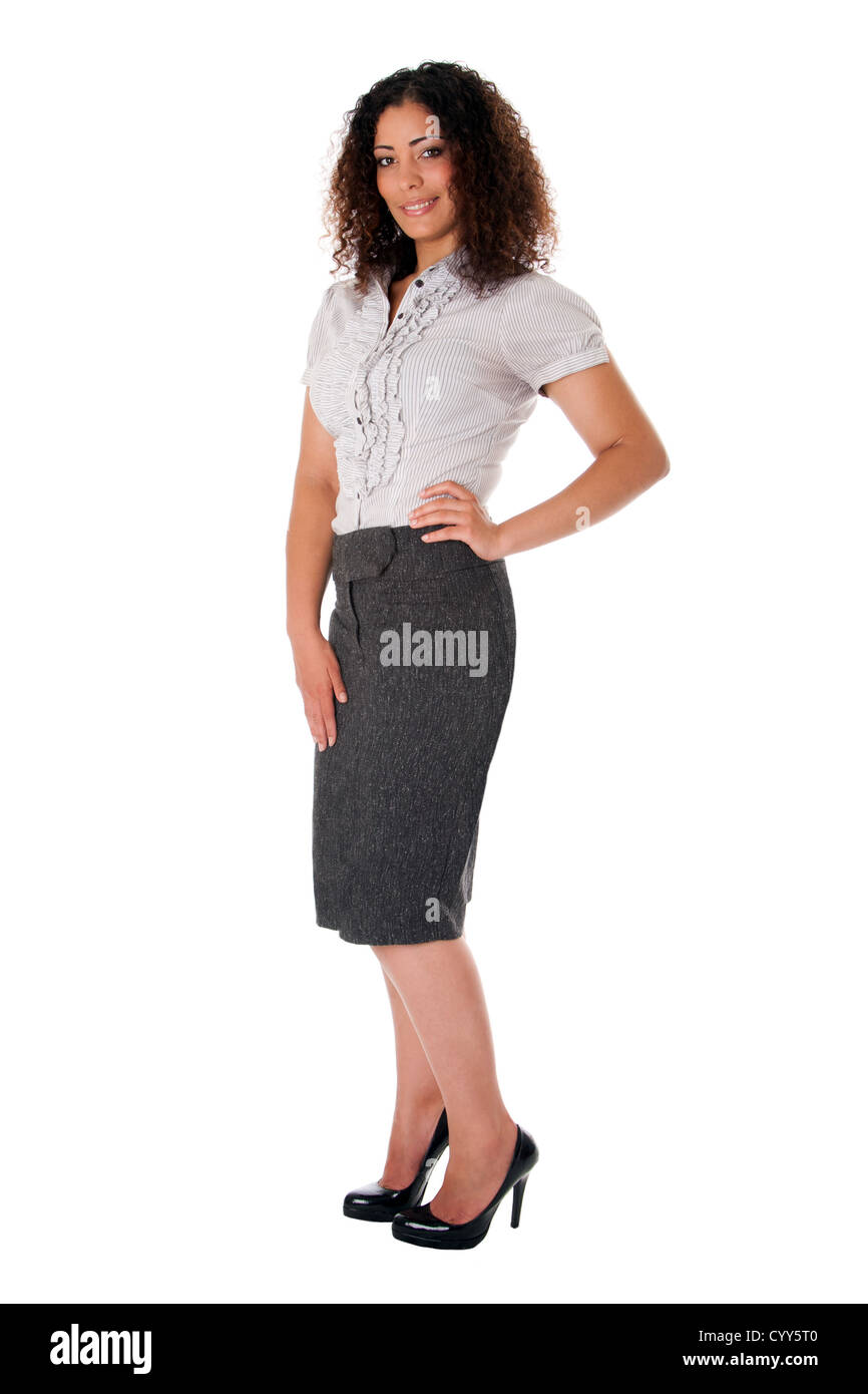 Sûr brunette frisée corporate business woman standing with hand on hip et souriant en jupe chemisier, pompes noir Banque D'Images