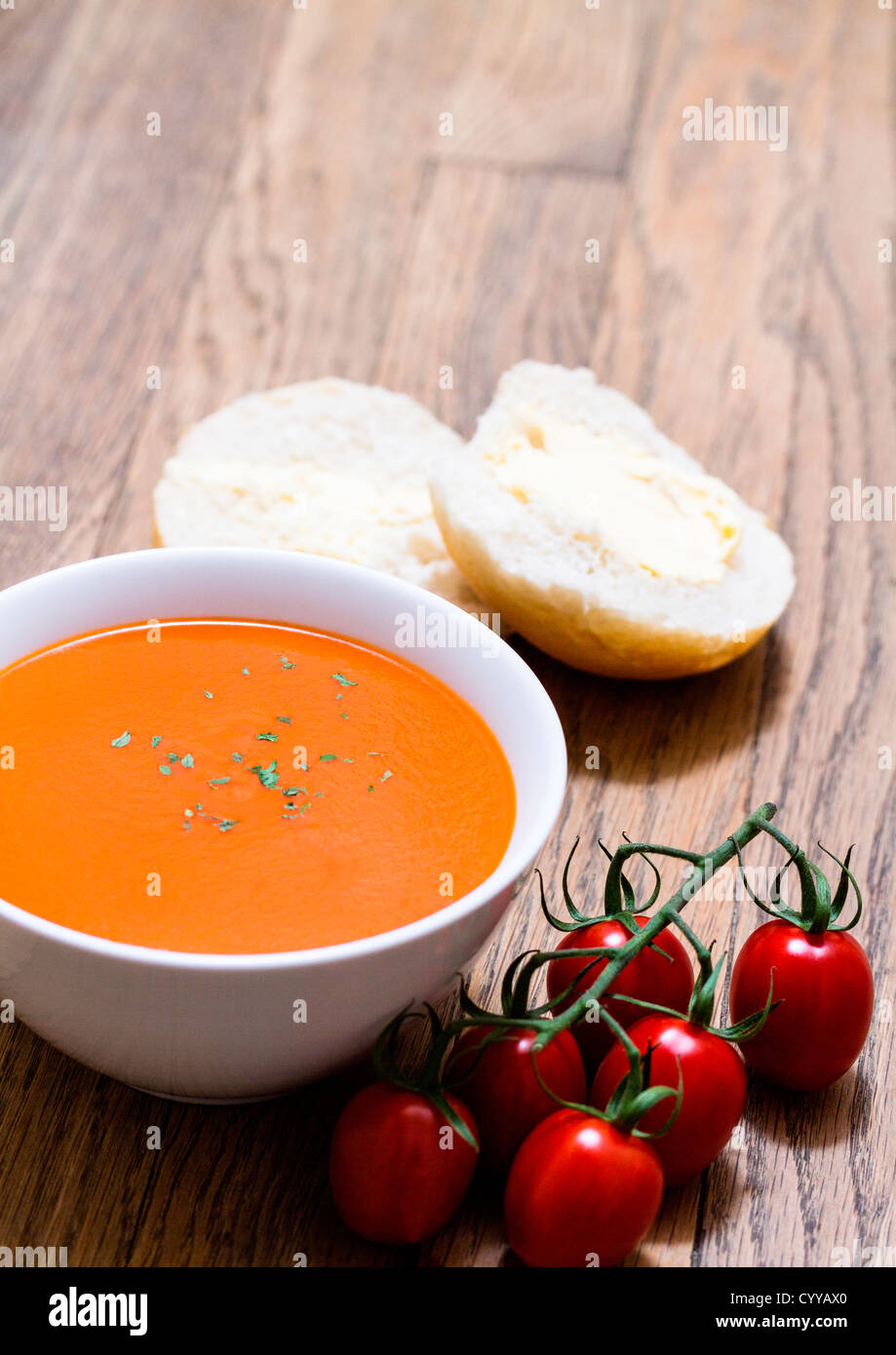 Soupe de tomates au basilic luxueux, des tomates et des rouleaux sur la vigne Banque D'Images