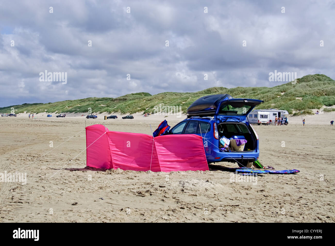 Une voiture familiale bleu sur la plage avec un pare-brise rose Banque D'Images