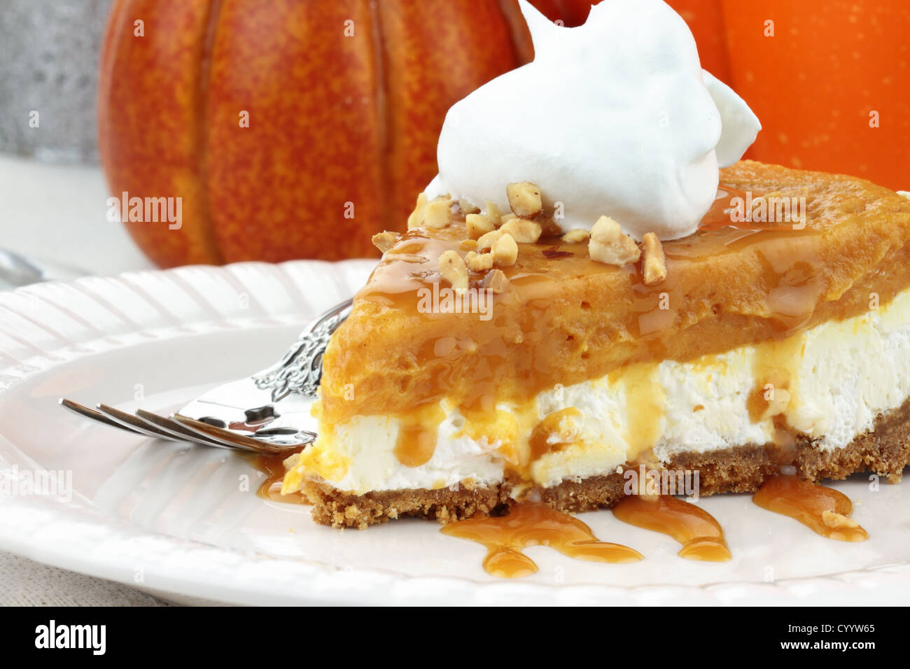 Double couche tranche de tarte à la citrouille sans cuisson faite avec la citrouille, pouding à la vanille,le fromage à la crème, et la crème fouettée. Banque D'Images