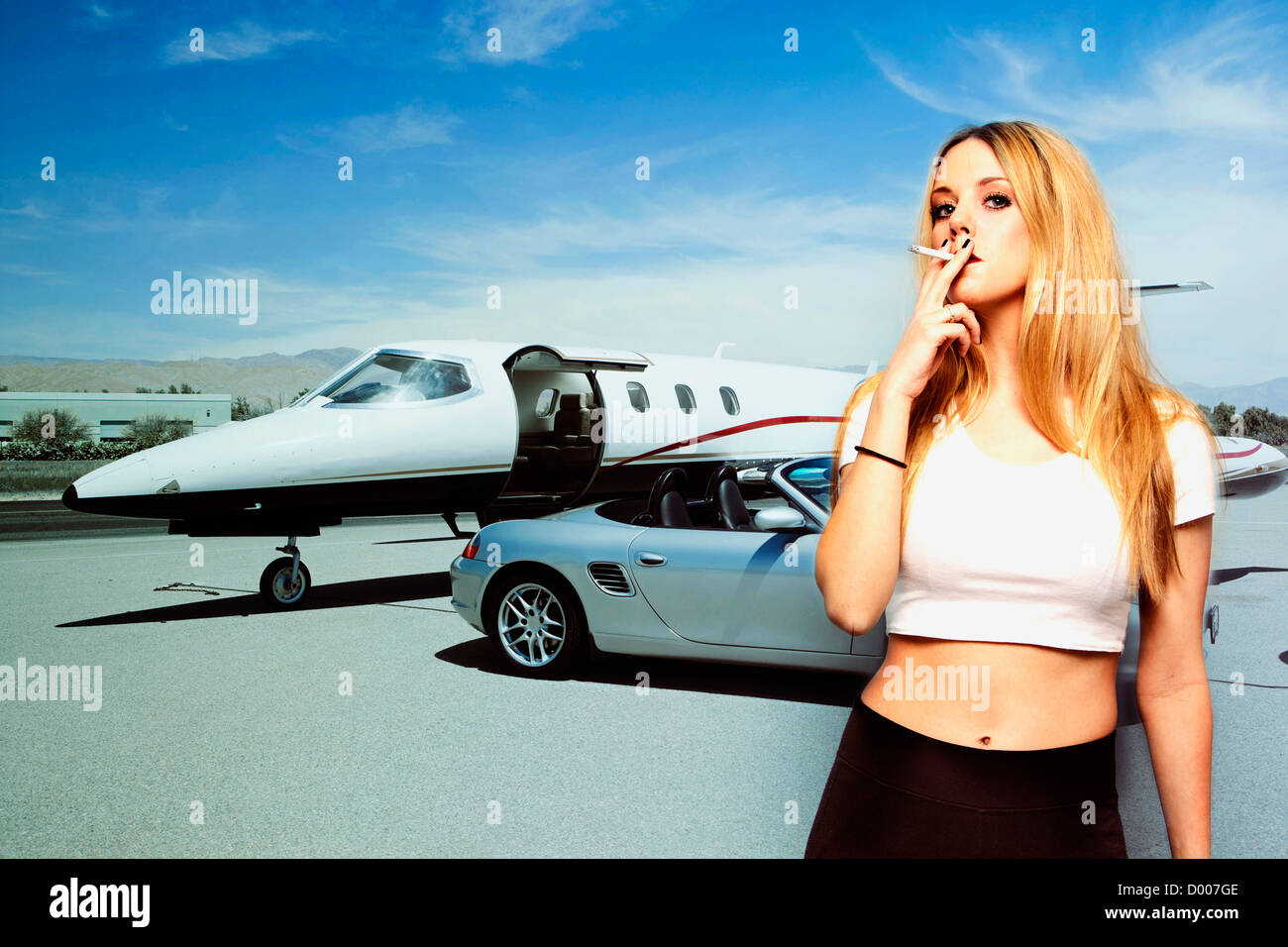 Portrait de jeune femme qui fume cigarette avec voiture et avion à l'arrière-plan Banque D'Images