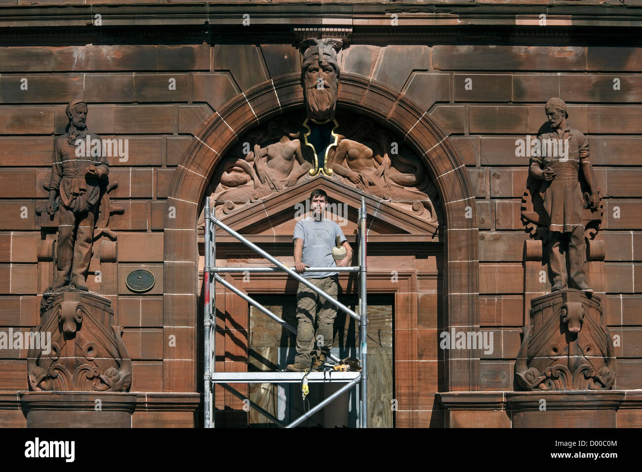 David Carty, un sculpteur sur pierre, la réparation de la sculpture en grès endommagés sur l'entrée principale de l'établissement Fairfield Shipyard, Govan Road, Gla Banque D'Images