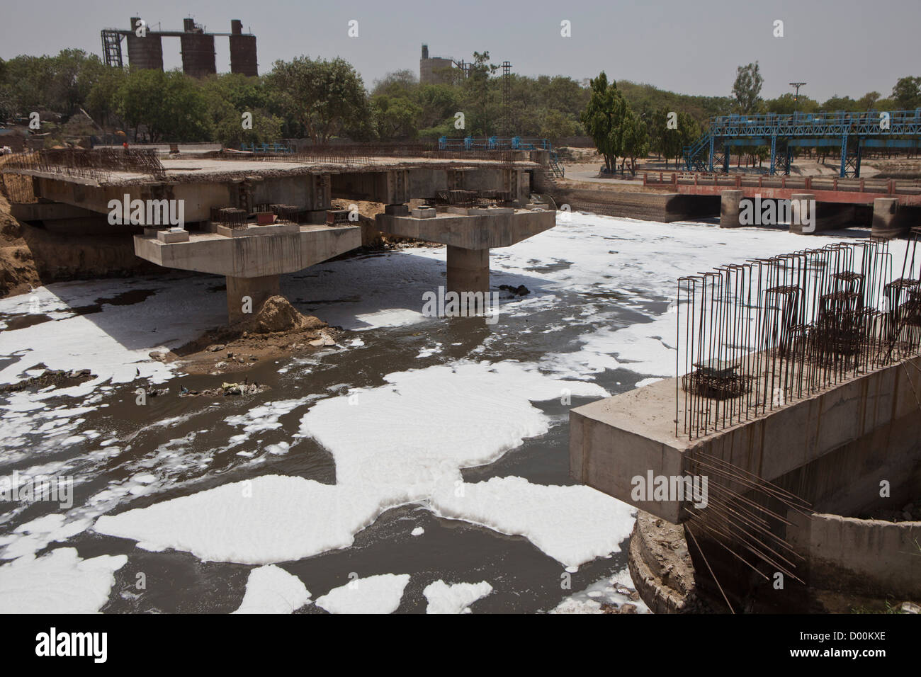 Formes de mousse sur une rivière polluée qui s'étend le long Mithapur Kalindi Kunj Road, Bangalore, Delhi, Inde. Banque D'Images