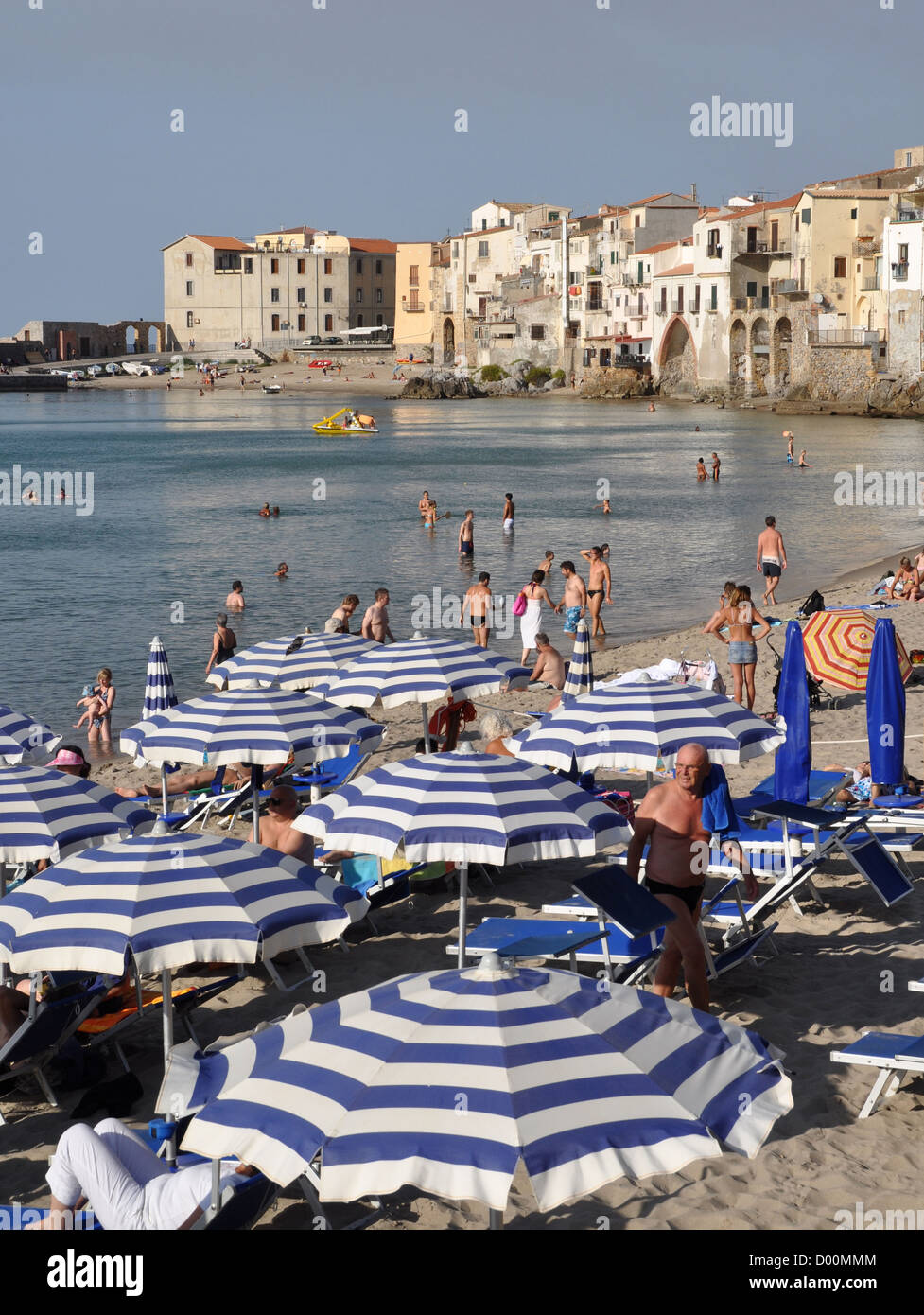 Blanc/bleu parasols sur la plage de Cefalù, Sicile, Italie Banque D'Images