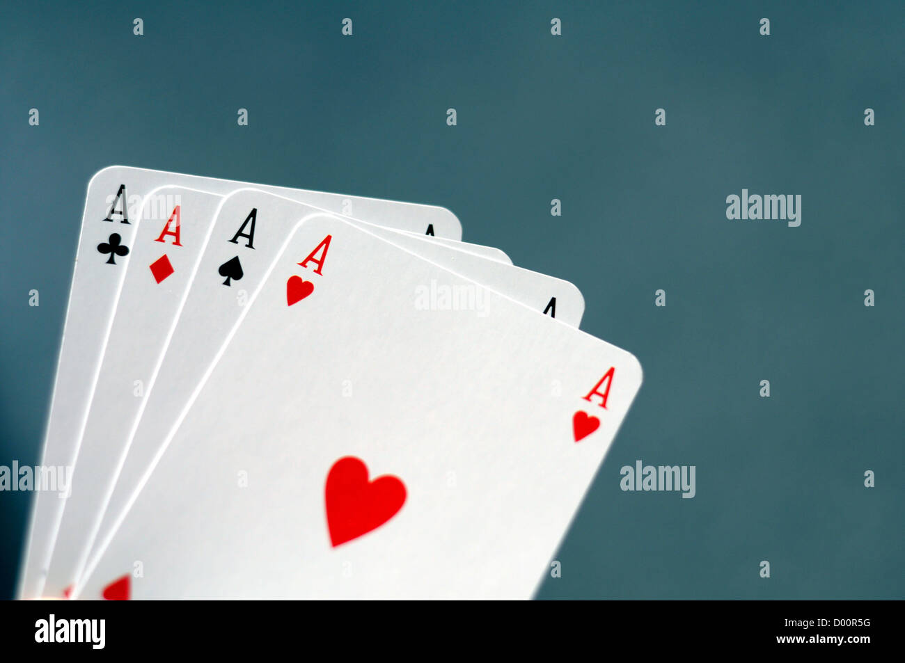 Main tenant quatre As avec bokeh copyspace Banque D'Images